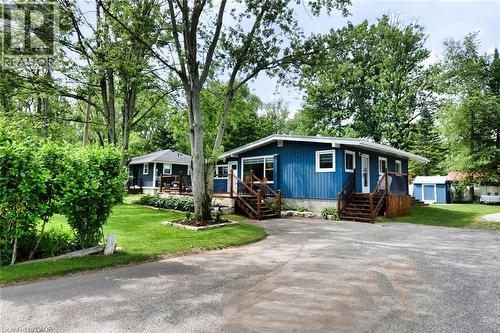 Blue exterior with white trim, featuring multiple entry points with wood stairs and railings - 5 Ralph Street, Turkey Point, ON - Outdoor