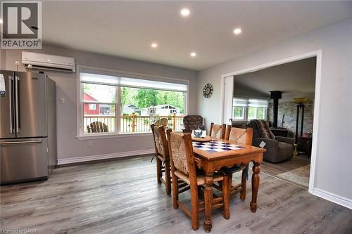 Open-concept dining area featuring wood-finish flooring, recessed lighting, and a wide window overlooking a deck - 5 Ralph Street, Turkey Point, ON - Indoor Photo Showing Dining Room