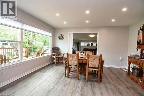 Dining area featuring wide plank wood-finish flooring, recessed ceiling lighting, and a large picture window overlooking a deck - 5 Ralph Street, Turkey Point, ON - Indoor Photo Showing Dining Room