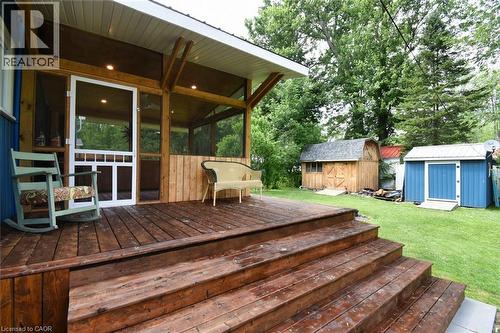 Expansive wooden deck with multi-level stairs leading to a screened-in porch with recessed lighting - 5 Ralph Street, Turkey Point, ON - Outdoor With Deck Patio Veranda