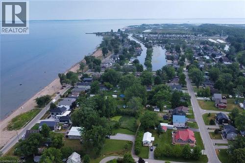 Aerial perspective showcasing a residential area bordered by a large body of water with a sandy shoreline - 5 Ralph Street, Turkey Point, ON - Outdoor With Body Of Water With View