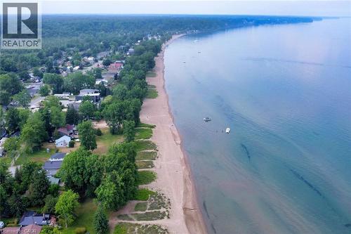 Expansive coastal setting featuring a sandy beach, mature tree line, and tranquil body of water - 5 Ralph Street, Turkey Point, ON - Outdoor With Body Of Water With View
