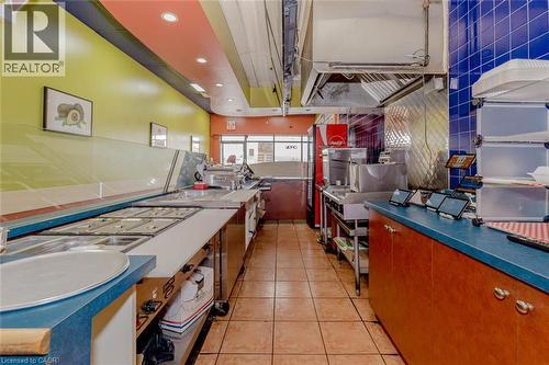 Commercial kitchen space featuring stainless steel preparation counters, tiled flooring, and recessed lighting - 1035 Brant Street Unit# 1C, Burlington, ON 