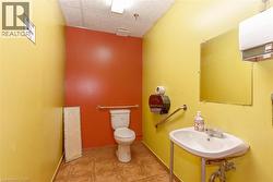 Restroom with a wall-mounted sink, a toilet, and grab bars - 