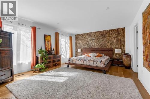 Spacious bedroom featuring wood-finish flooring, recessed lighting, and ample natural light from multiple windows - 39 Hilts Drive, Stoney Creek, ON - Indoor Photo Showing Bedroom