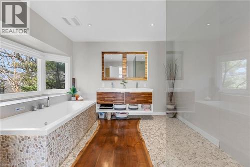 Spacious bathroom featuring a built-in soaking tub with pebble tile surround and expansive bay window - 39 Hilts Drive, Stoney Creek, ON - Indoor Photo Showing Bathroom