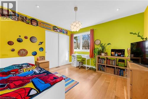 Bright room featuring wood-finish flooring, a large window, a built-in closet with sliding doors, an overhead pendant light fixture, and recessed ceiling lighting - 39 Hilts Drive, Stoney Creek, ON - Indoor Photo Showing Bedroom
