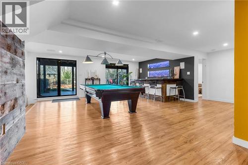 Spacious recreation room featuring wood-finish flooring, recessed lighting, and a built-in bar with pendant lighting - 39 Hilts Drive, Stoney Creek, ON - Indoor Photo Showing Other Room