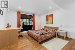 Bright interior space featuring recessed lighting, a large window, wood-finish flooring, and crisp white walls - 