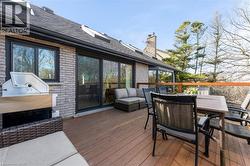 Expansive wood-finish deck with a wood railing, providing ample space for outdoor seating and entertaining - 