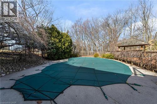 Outdoor pool area featuring a covered pool, concrete surround, a wooden gazebo with a shingle roof, and established perimeter plantings - 39 Hilts Drive, Stoney Creek, ON - Outdoor With In Ground Pool