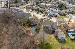 Rear exterior with extensive wooded area, featuring a multi-level deck, a swimming pool, and multiple skylights - 
