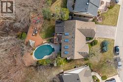 Expansive backyard featuring a freeform pool, multi-level wood decking, and mature trees - 