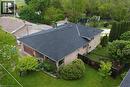 Brick exterior residence featuring a dark shingle roof, attached garage with a wood-panel door, and a covered front porch - 64 Winnett Street N, Cayuga, ON 