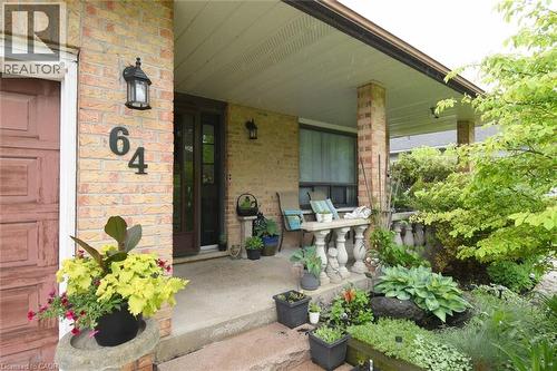 Covered front porch featuring brick columns and a concrete floor - 64 Winnett Street N, Cayuga, ON 