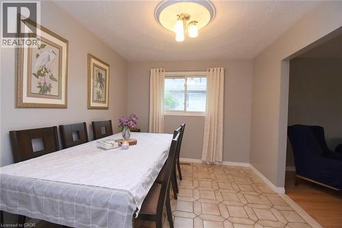 Dining area featuring geometric tile flooring and a window with natural light - 64 Winnett Street N, Cayuga, ON 