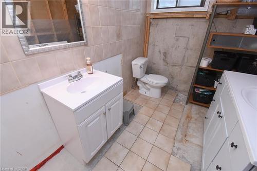 Bathroom featuring a white vanity with integrated sink, chrome faucet, and tiled wall - 64 Winnett Street N, Cayuga, ON 