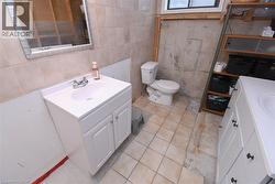 Bathroom featuring a white vanity with integrated sink, chrome faucet, and tiled wall - 