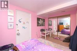Carpeted room featuring a full-wall mirrored closet, a white interior door, and light pink walls - 