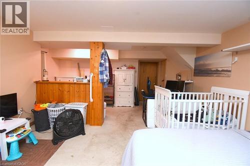 Finished lower level featuring a wood-paneled bar area and carpet flooring - 64 Winnett Street N, Cayuga, ON 