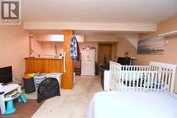 Finished lower level featuring a wood-paneled bar area and carpet flooring - 