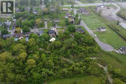 Expansive aerial presenting a residential area featuring established homes, green spaces, and paved streets - 