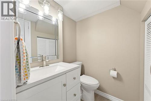 Bathroom vanity with a white countertop and integrated sink, brushed nickel faucet, and a large mirror with overhead lighting - 26 Coachwood Road Unit# 6, Brantford, ON - Indoor Photo Showing Bathroom
