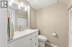 Bathroom vanity with a white countertop and integrated sink, brushed nickel faucet, and a large mirror with overhead lighting - 