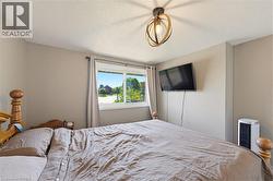 Neutral-toned interior featuring a double-paned window, a ceiling-mounted light fixture with a geometric design, and painted walls - 