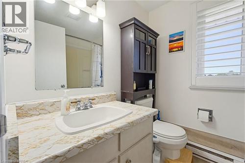 Bathroom featuring a vanity with a patterned countertop, a built-in sink, and a chrome faucet - 26 Coachwood Road Unit# 6, Brantford, ON - Indoor Photo Showing Bathroom