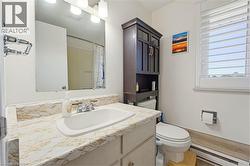 Bathroom featuring a vanity with a patterned countertop, a built-in sink, and a chrome faucet - 