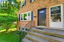Brick exterior featuring a black paneled door with an arched window, white-framed windows, and black louvered shutters - 26 Coachwood Road Unit# 6, Brantford, ON  - Outdoor With Exterior 