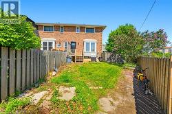 Brick exterior featuring white-framed windows, a rear entry door, and exterior stairs - 