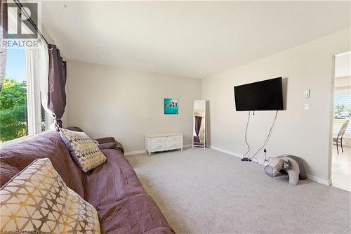 Carpeted living space with a large picture window, offering abundant natural light - 26 Coachwood Road Unit# 6, Brantford, ON - Indoor Photo Showing Bedroom
