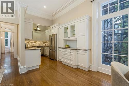 Kitchen with stainless steel appliances, dark wood finished floors, dark stone countertops, white cabinets, and crown molding - 46 Herkimer Street Unit# 2, Hamilton, ON - Indoor Photo Showing Kitchen