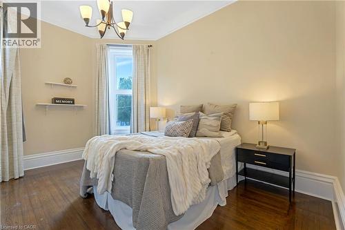 Bedroom with dark wood-style flooring, crown molding, and a chandelier - 46 Herkimer Street Unit# 2, Hamilton, ON - Indoor Photo Showing Bedroom