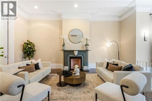 Living room with ornamental molding, wood finished floors, recessed lighting, and a premium fireplace - 46 Herkimer Street Unit# 2, Hamilton, ON - Indoor Photo Showing Living Room With Fireplace