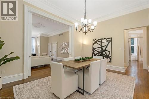 Dining space featuring crown molding, dark wood finished floors, and a chandelier - 46 Herkimer Street Unit# 2, Hamilton, ON - Indoor