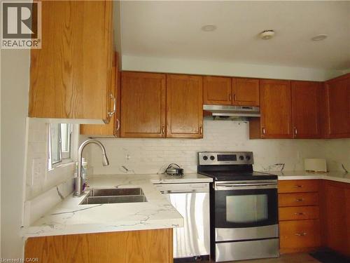 Kitchen featuring wood-finish cabinetry and light-toned countertops - 90 Bridlewreath Street Unit# Upper Unit, Kitchener, ON - Indoor Photo Showing Kitchen With Double Sink