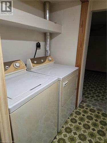 Laundry area featuring a built-in shelf, wood trim, and patterned flooring - 95 Fonthill Road Unit# 2, Hamilton, ON - Indoor Photo Showing Laundry Room