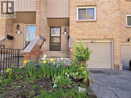 Brick facade townhome with an attached garage, a paved driveway, and a welcoming front entrance with an ornamental railing - 95 Fonthill Road Unit# 2, Hamilton, ON - Outdoor With Exterior