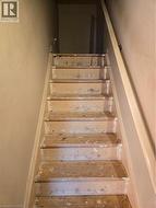 Staircase featuring wood treads and risers, with a light-toned handrail - 