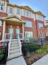 Townhouse exterior featuring brick and siding construction, covered front entrance, concrete steps with white railings, and a fenced front yard with plantings - 146 Watson Parkway, Guelph, ON  - Outdoor 