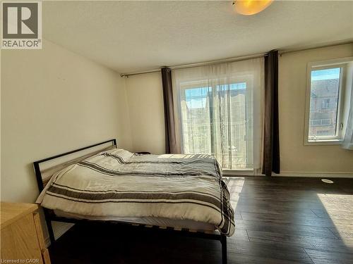 Spacious room featuring wood-finish flooring, light-toned walls, and a ceiling-mounted light fixture - 146 Watson Parkway, Guelph, ON - Indoor Photo Showing Bedroom