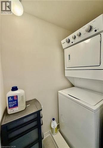 Dedicated laundry space featuring a stacked washer and dryer unit - 146 Watson Parkway, Guelph, ON - Indoor Photo Showing Laundry Room