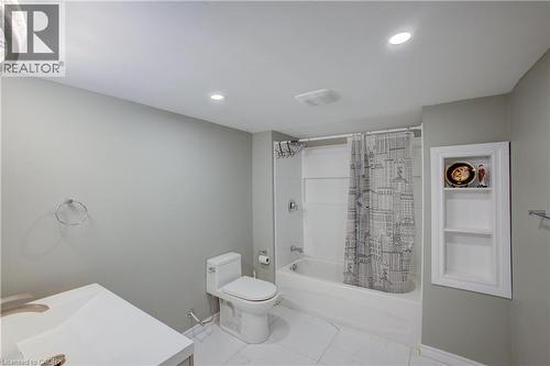 Bathroom featuring a white vanity with integrated sink, a built-in bathtub with shower, recessed lighting, and a wall-mounted storage niche - 53 Prosperity Drive, Kitchener, ON - Indoor Photo Showing Bathroom