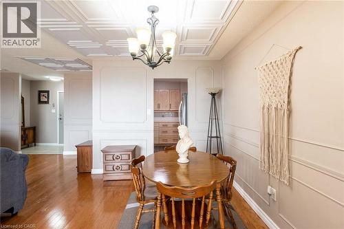 Dining area featuring a decorative ceiling, wood-finish flooring, and wainscoting details on the walls - 500 Green Road Unit# 901, Stoney Creek, ON - Indoor Photo Showing Dining Room
