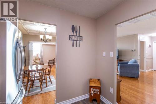 Interconnected living spaces featuring warm wood-finish flooring, white baseboards, and neutral wall tones - 500 Green Road Unit# 901, Stoney Creek, ON - Indoor