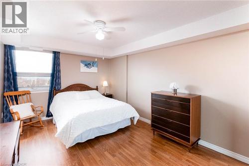 Spacious room featuring wood-finish flooring, a large window, neutral wall tones, and a ceiling fan - 500 Green Road Unit# 901, Stoney Creek, ON - Indoor Photo Showing Bedroom