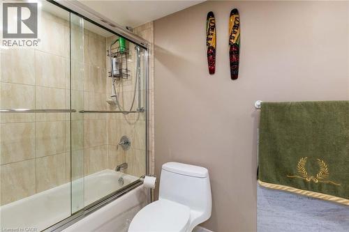 Bathroom featuring a white tub, chrome fixtures, and a tiled shower surround with glass sliding doors - 500 Green Road Unit# 901, Stoney Creek, ON - Indoor Photo Showing Bathroom